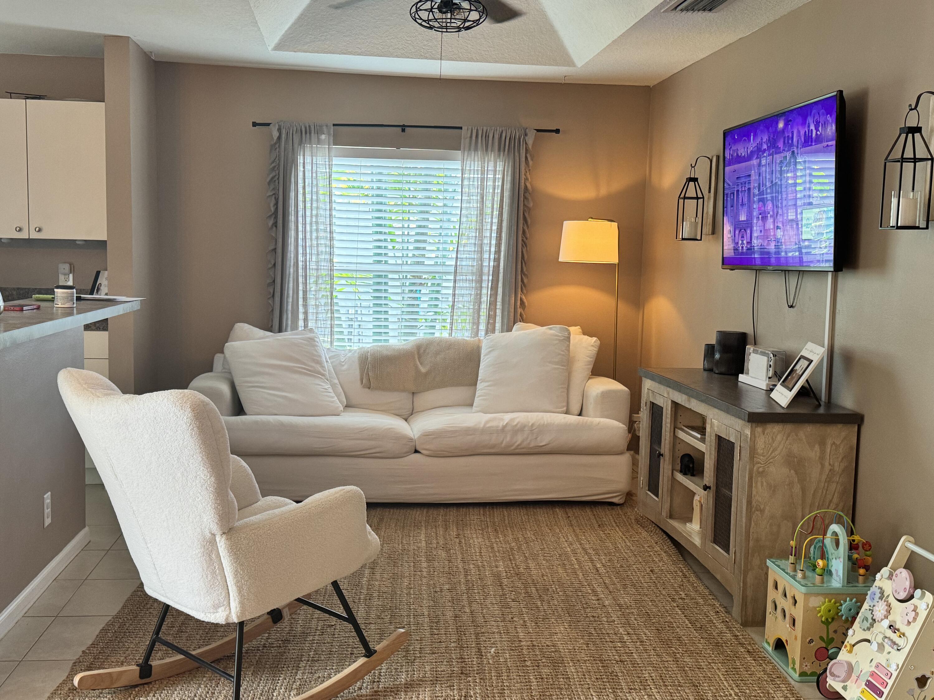 4571 Southeast Murray Cove Circle Stuart, FL 34997 - Photo 12 of 35 a living room with furniture and a flat screen tv
