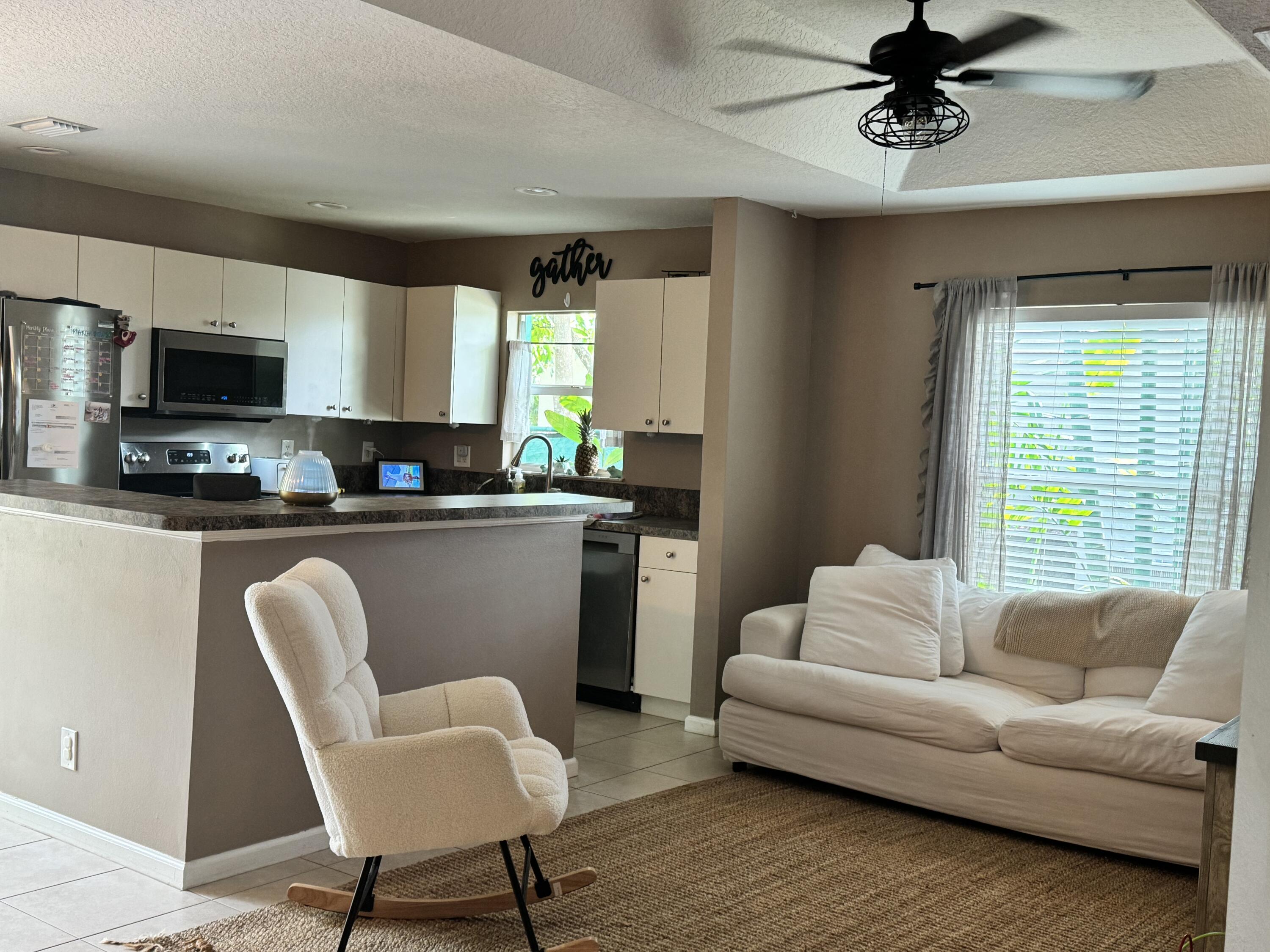4571 Southeast Murray Cove Circle Stuart, FL 34997 - Photo 14 of 35 a living room with furniture a window and a fireplace