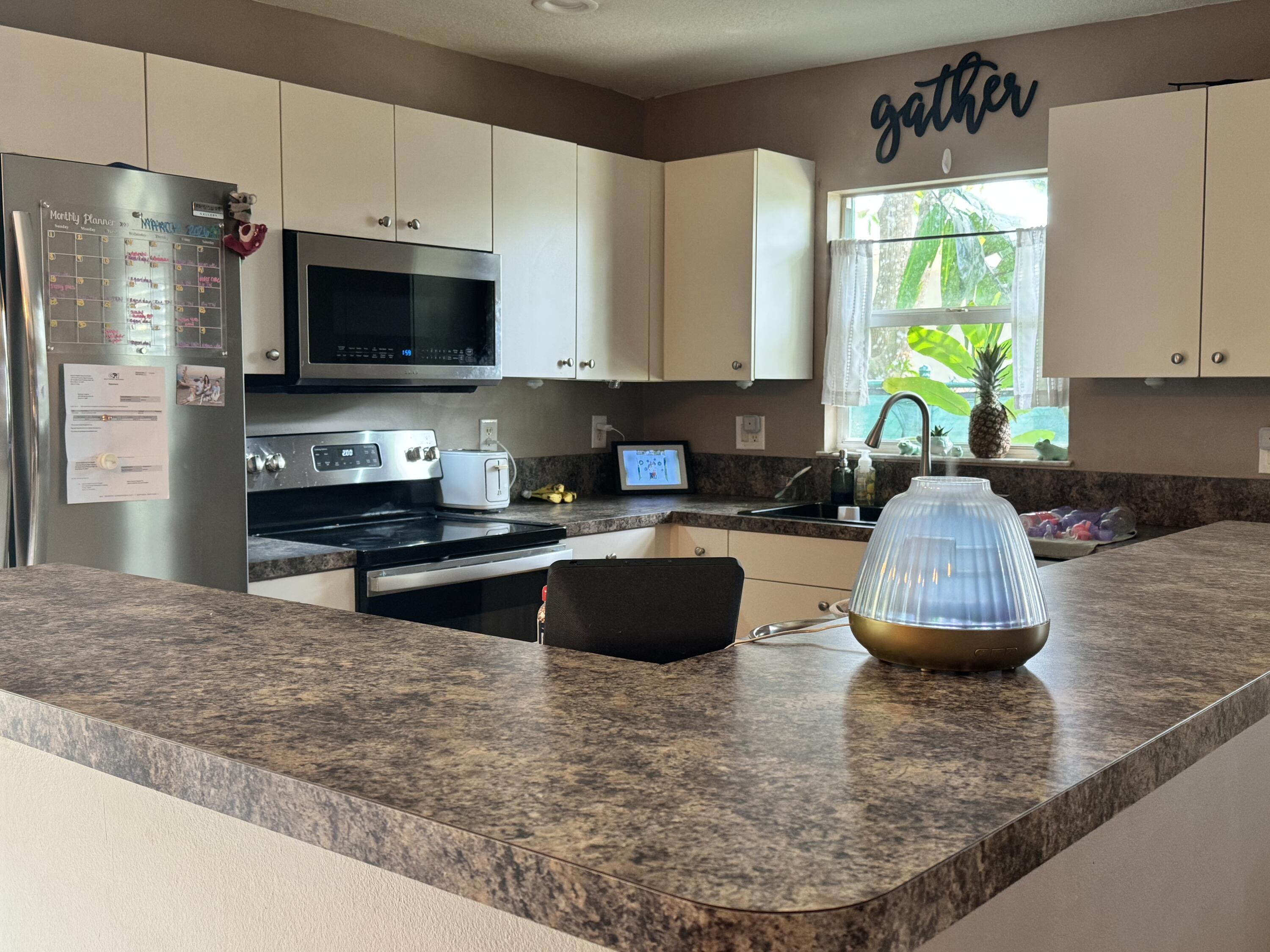 4571 Southeast Murray Cove Circle Stuart, FL 34997 - Photo 17 of 35 a kitchen with stainless steel appliances granite countertop a stove a sink a microwave and refrigerator