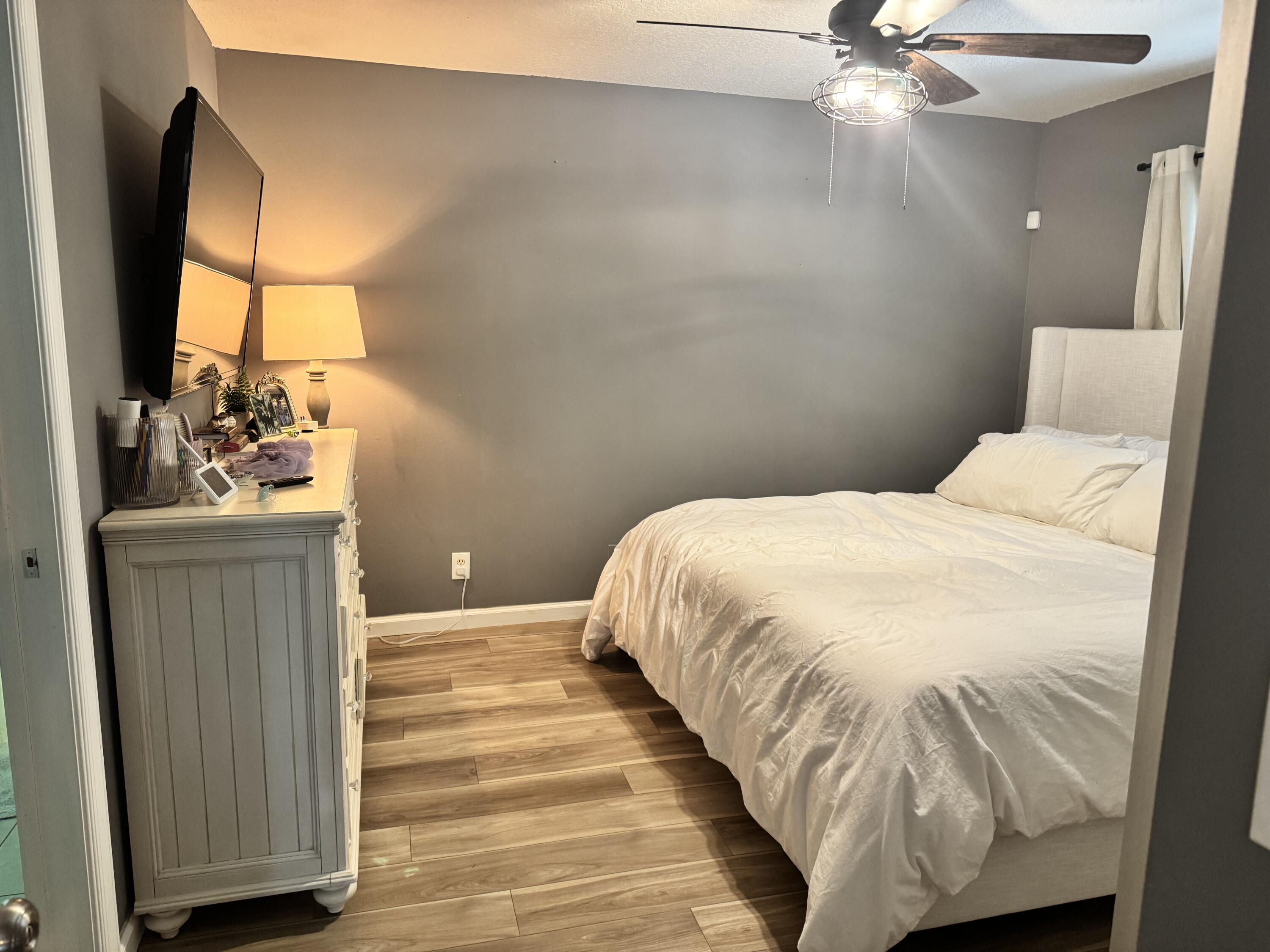 4571 Southeast Murray Cove Circle Stuart, FL 34997 - Photo 19 of 35 a bedroom with a bed and a chandelier