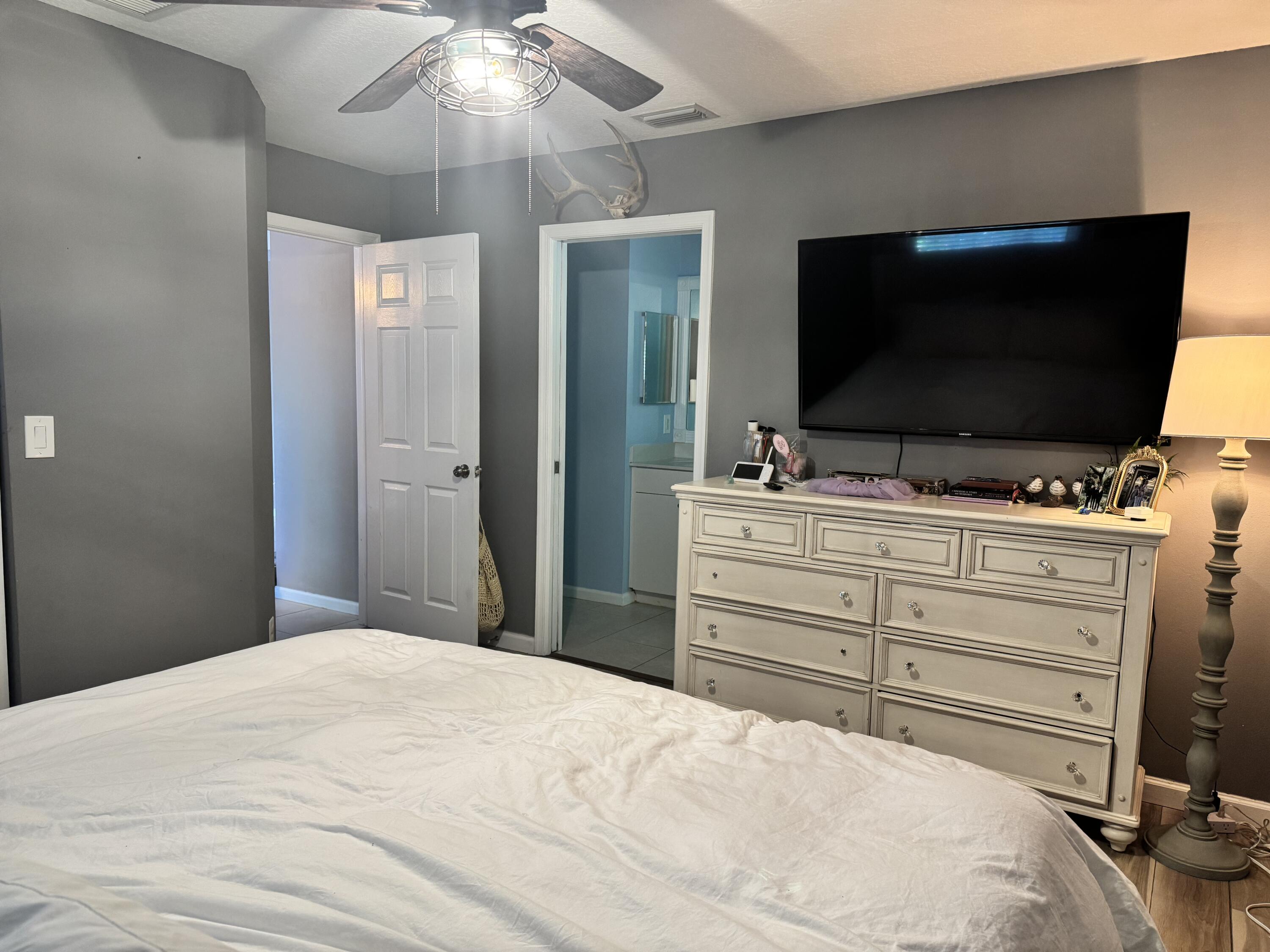 4571 Southeast Murray Cove Circle Stuart, FL 34997 - Photo 20 of 35 a bedroom with a bed and a flat screen tv