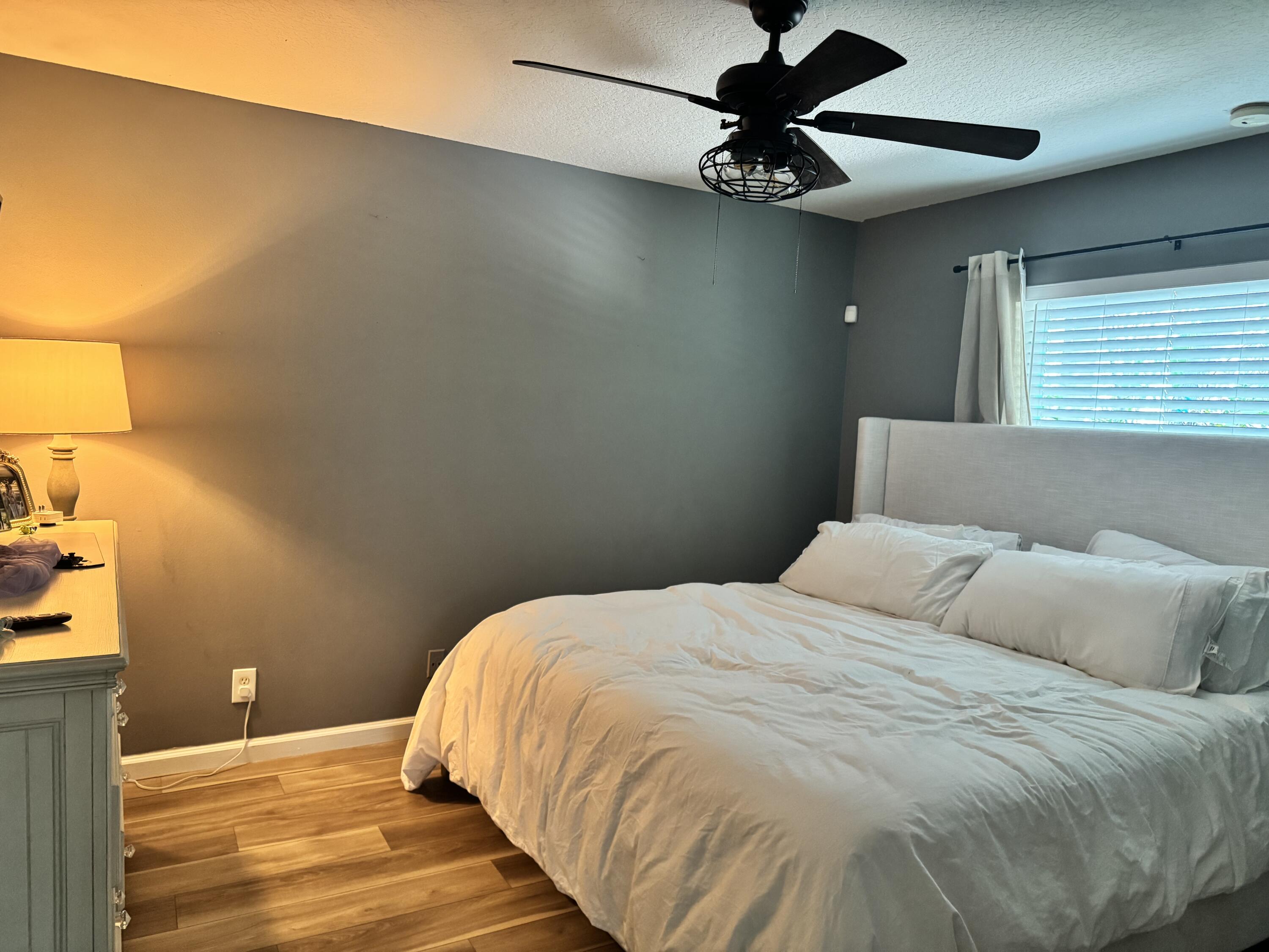 4571 Southeast Murray Cove Circle Stuart, FL 34997 - Photo 21 of 35 a bedroom with a bed and a ceiling fan
