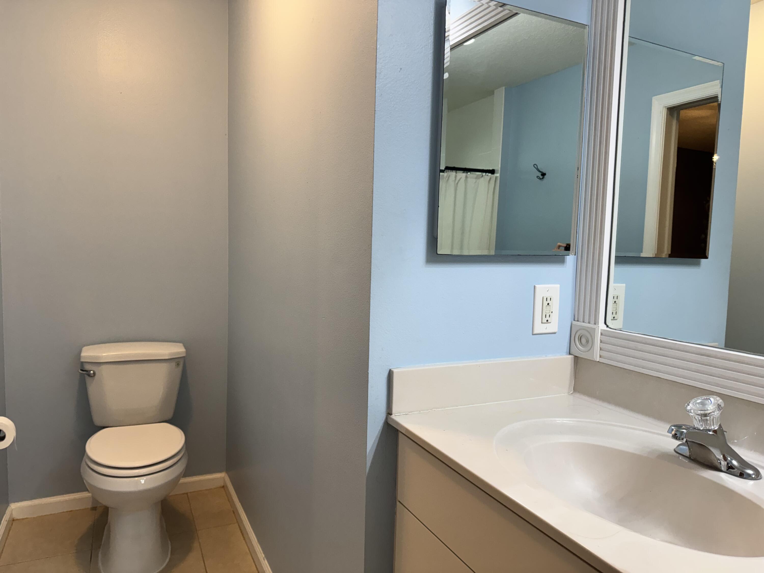4571 Southeast Murray Cove Circle Stuart, FL 34997 - Photo 23 of 35 a bathroom with a sink a toilet and mirror