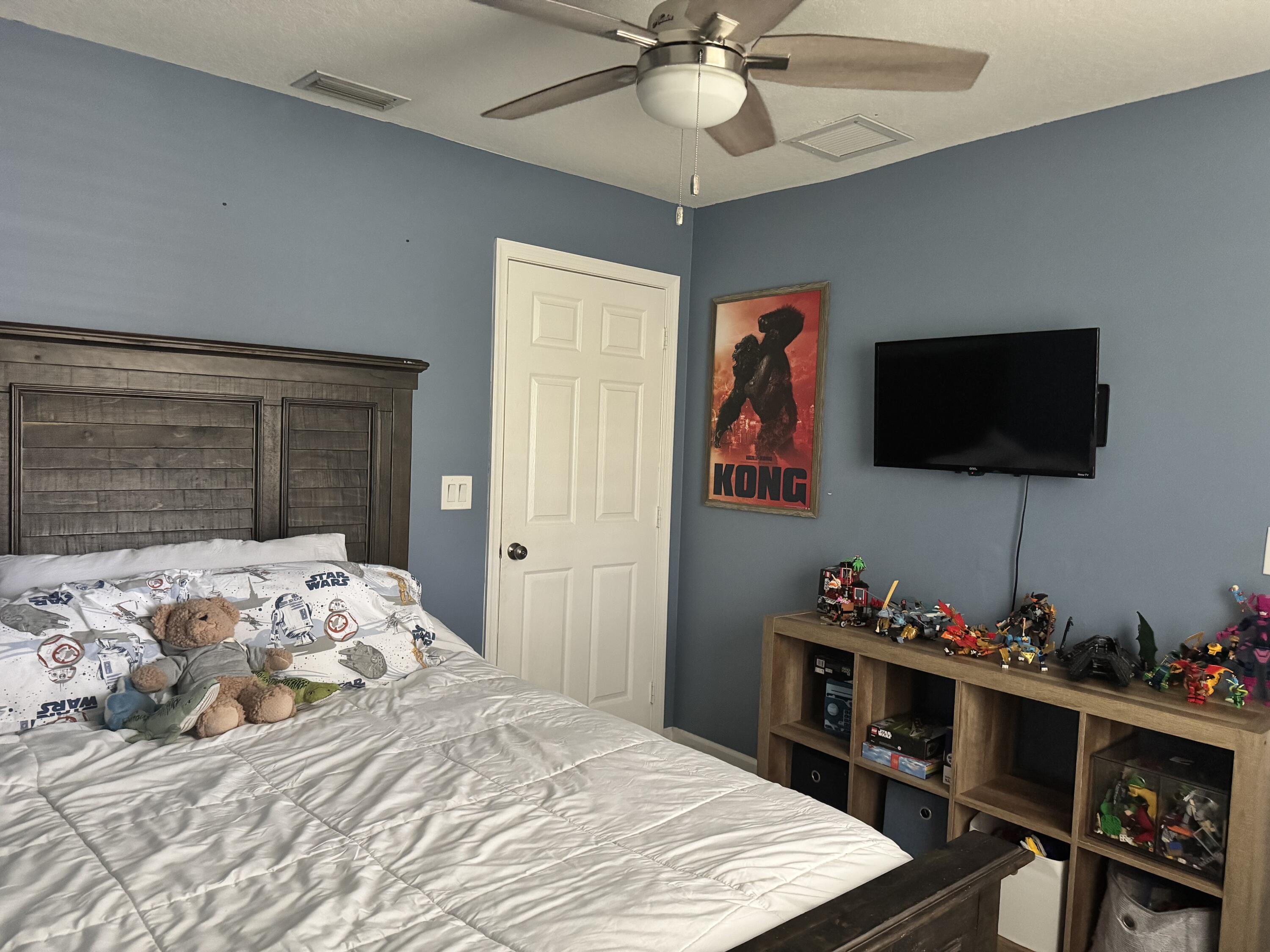 4571 Southeast Murray Cove Circle Stuart, FL 34997 - Photo 27 of 35 a bedroom with a bed and a flat screen tv