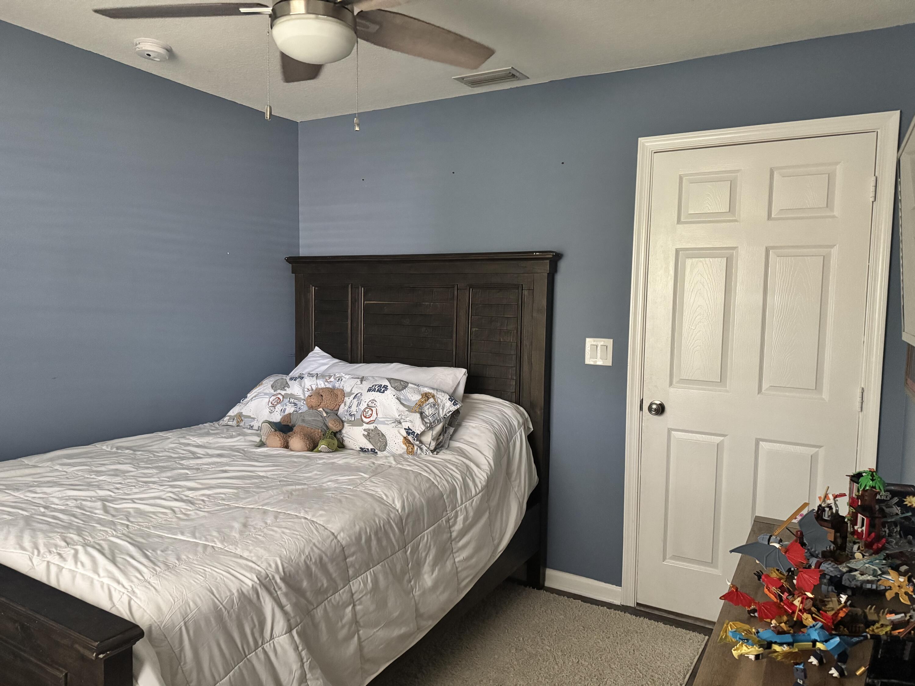 4571 Southeast Murray Cove Circle Stuart, FL 34997 - Photo 29 of 35 a bedroom with a bed and a chandelier