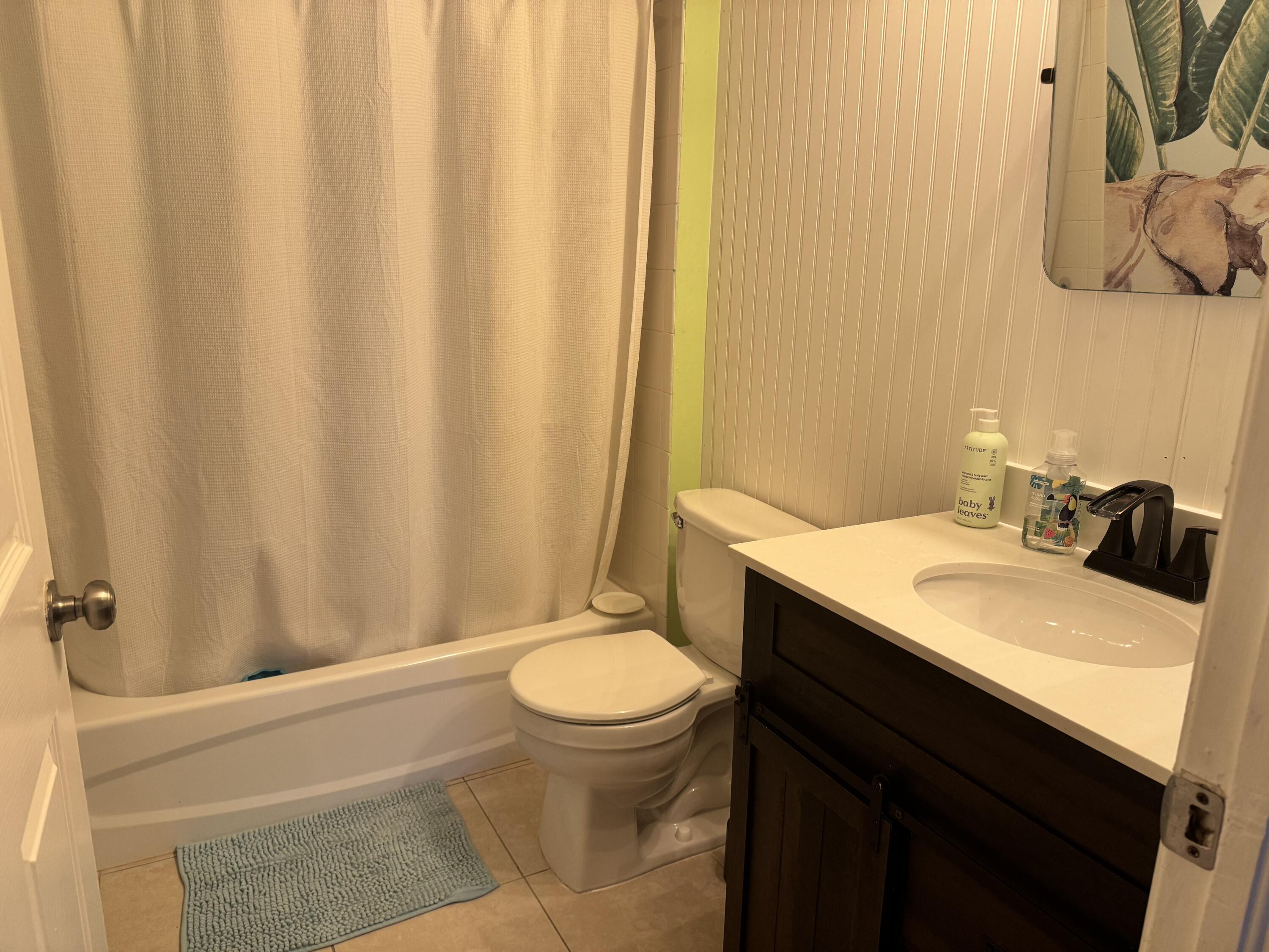 4571 Southeast Murray Cove Circle Stuart, FL 34997 - Photo 31 of 35 a bathroom with a sink a toilet and shower curtain