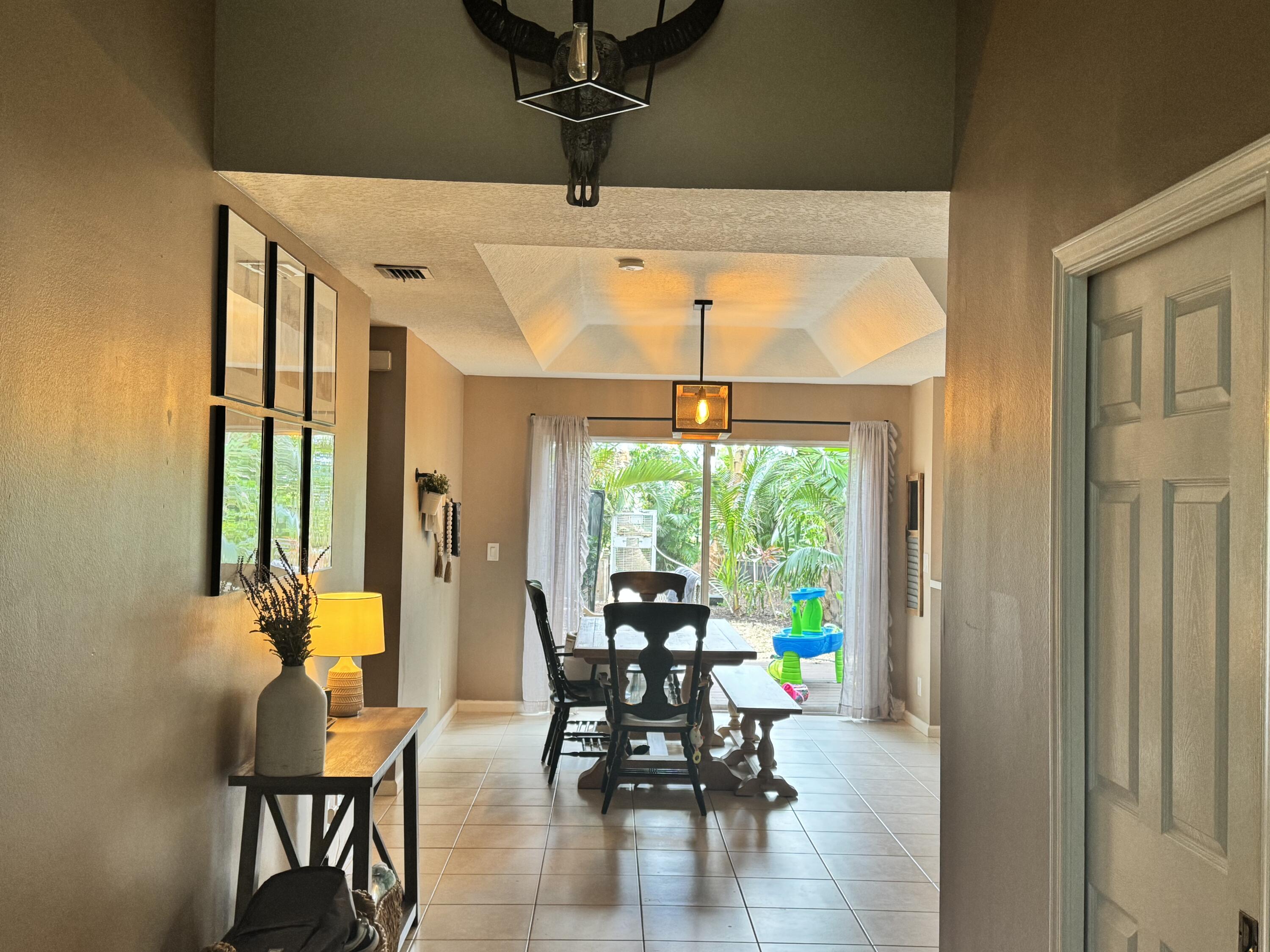 4571 Southeast Murray Cove Circle Stuart, FL 34997 - Photo 9 of 35 a dining room with furniture water view and a floor to ceiling window
