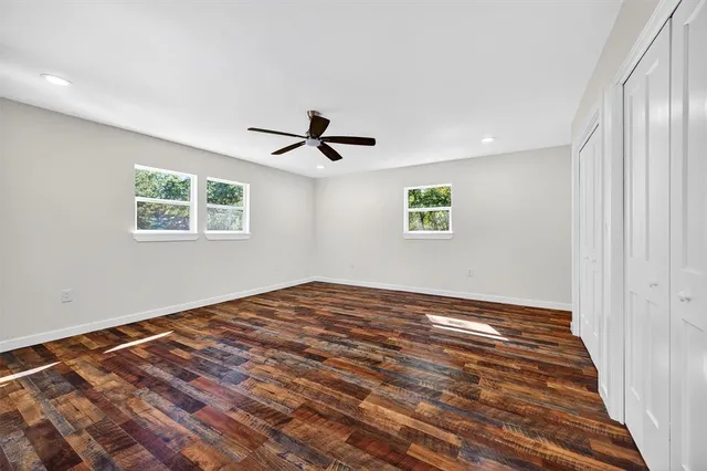a view of empty room with wooden floor and window