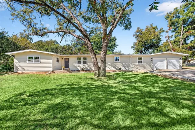 a view of house with backyard and a garden