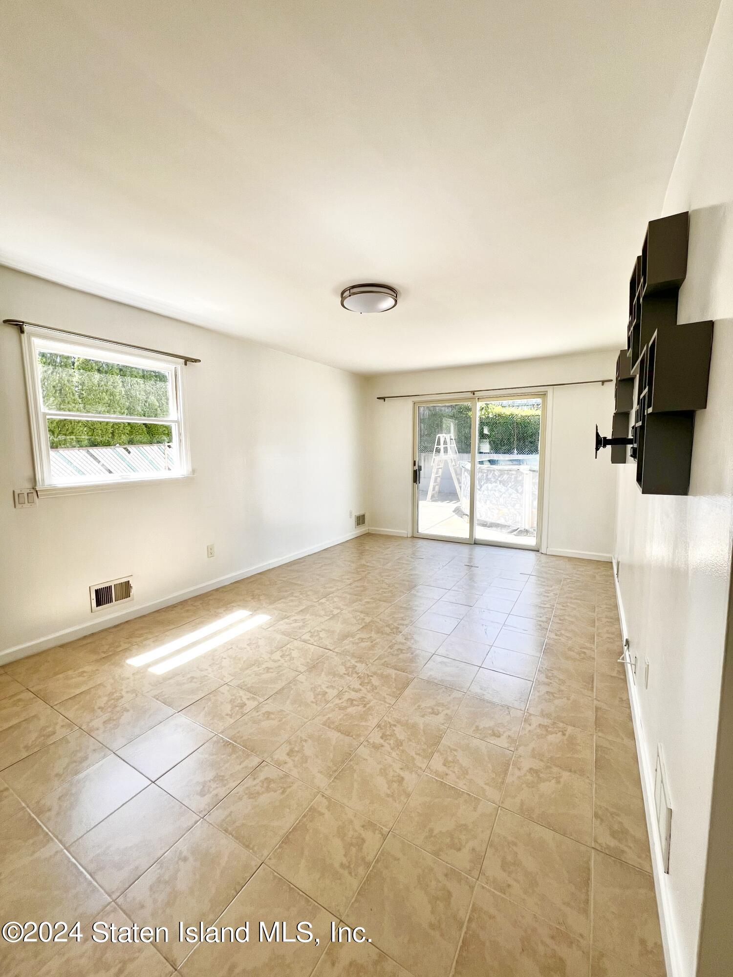 4 Futurity Place Staten Island, NY 10312 - Photo 19 of 26 a view of a livingroom with wooden floor and a flat screen tv