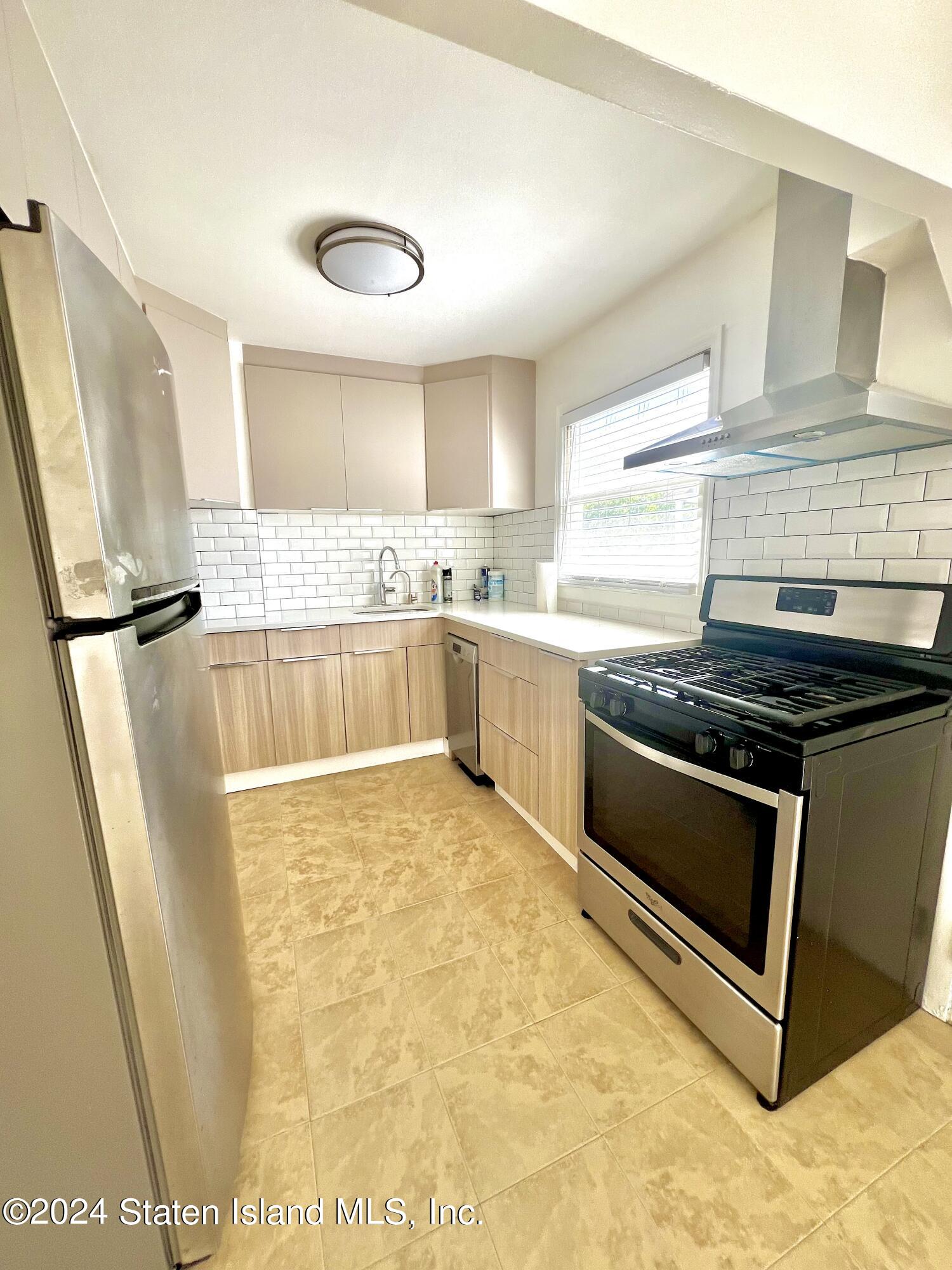 4 Futurity Place Staten Island, NY 10312 - Photo 21 of 26 a kitchen with stainless steel appliances granite countertop a stove a sink and a refrigerator
