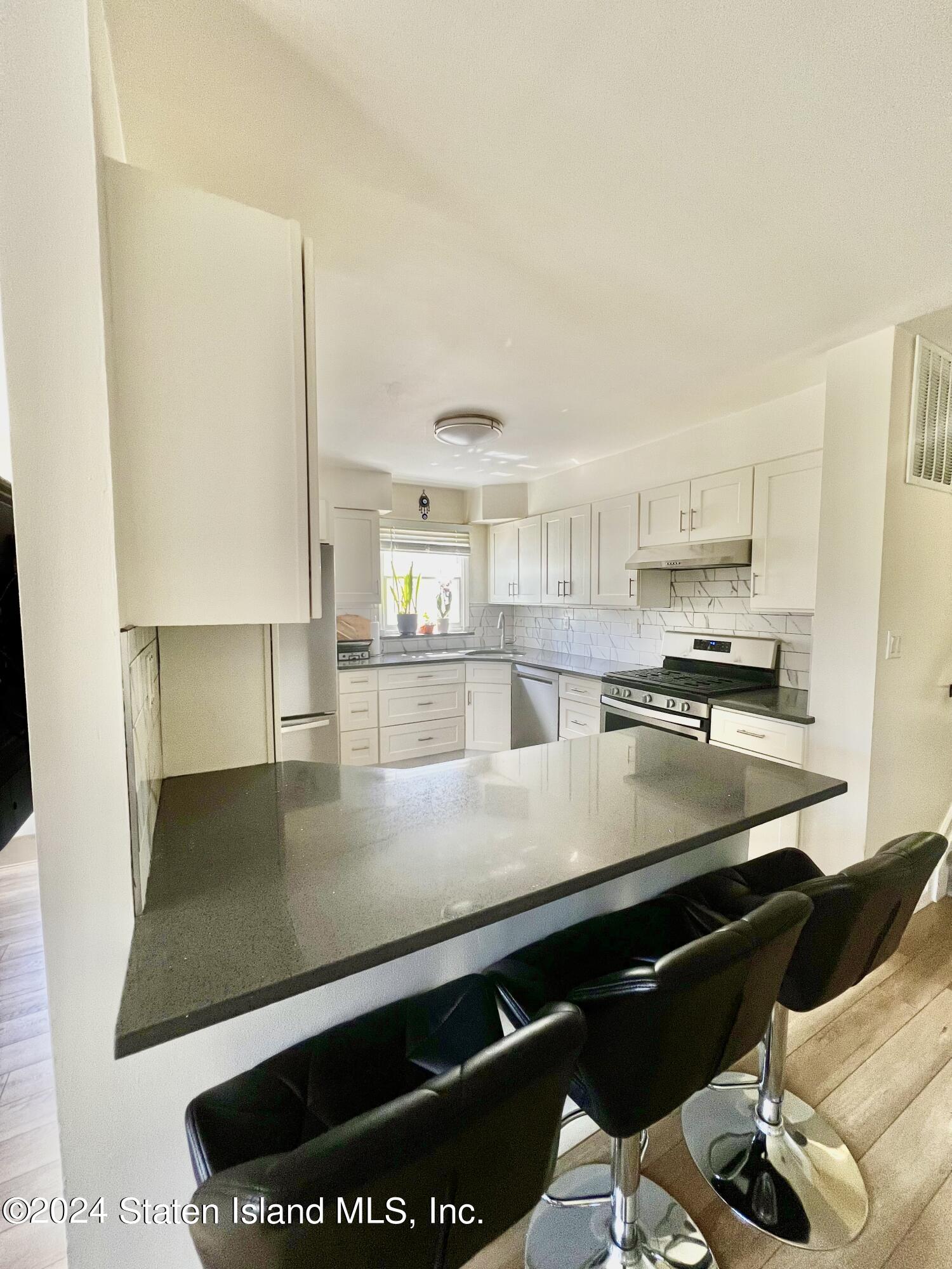 4 Futurity Place Staten Island, NY 10312 - Photo 8 of 26 a kitchen with stainless steel appliances granite countertop a sink a stove and a refrigerator