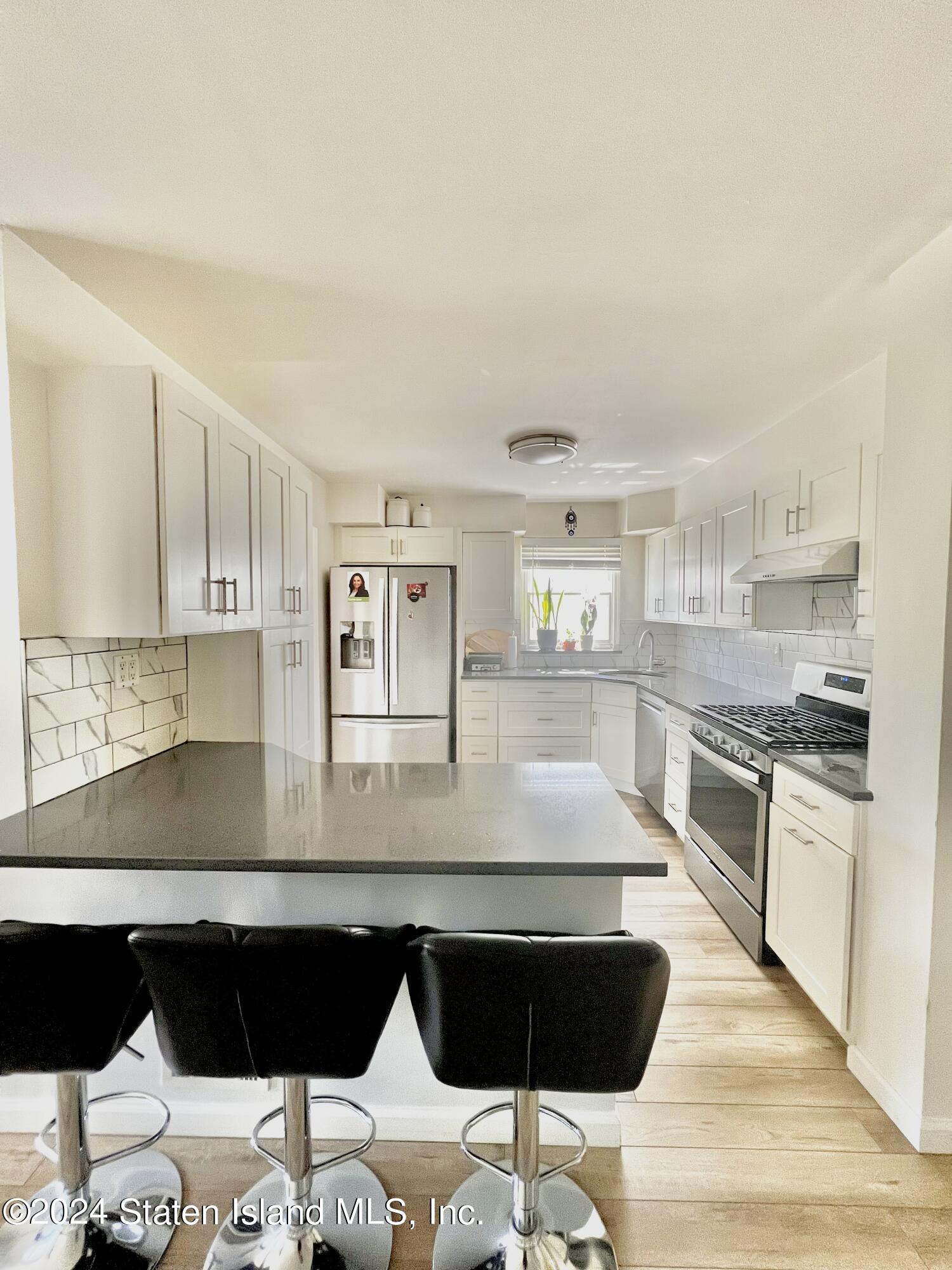 4 Futurity Place Staten Island, NY 10312 - Photo 9 of 26 a kitchen with a refrigerator and a stove top oven