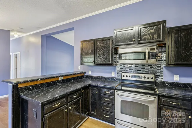 an empty room with chandelier fan and windows