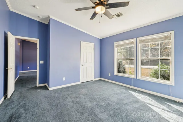 an empty room with closet and a chandelier fan