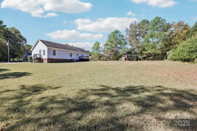 a view of a house with a backyard and a tree