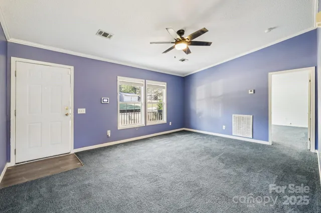 an empty room with windows and fan