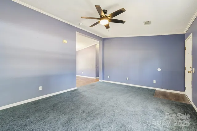 an empty room with closet and a ceiling fan