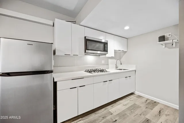 a kitchen with stainless steel appliances a refrigerator sink and microwave