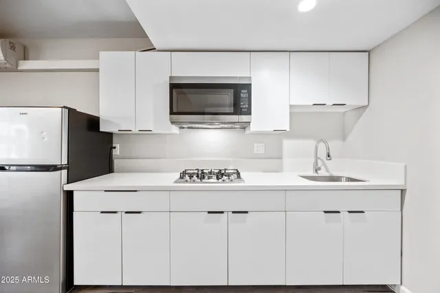 a kitchen with stainless steel appliances a microwave a sink and cabinets