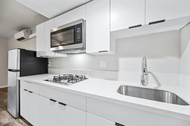 a kitchen with stainless steel appliances kitchen island a white counter space a sink and cabinets