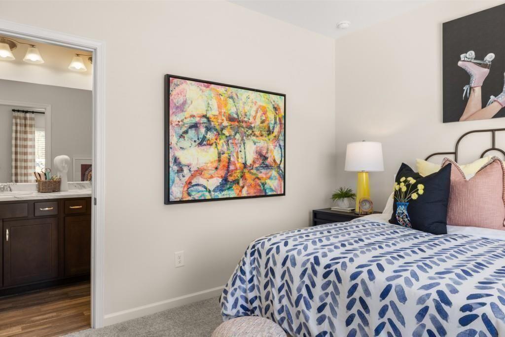 523 Grover Street Hoschton, GA 30548 - Photo 41 of 50 a bedroom with a bed and painting on the wall