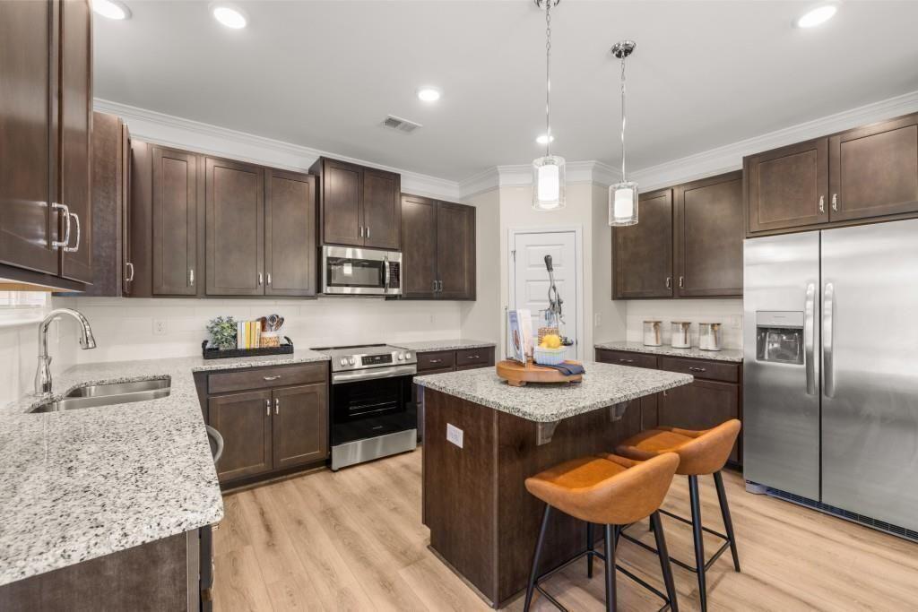 523 Grover Street Hoschton, GA 30548 - Photo 6 of 50 a kitchen with stainless steel appliances granite countertop a sink stove and refrigerator