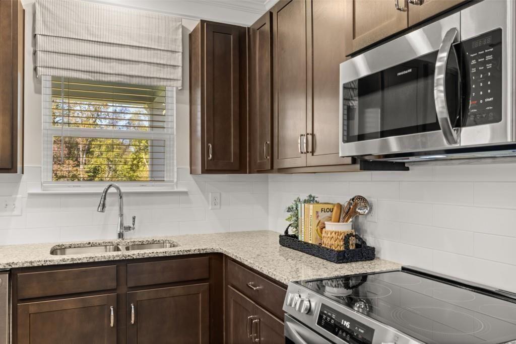 523 Grover Street Hoschton, GA 30548 - Photo 8 of 50 a kitchen with stainless steel appliances a sink a stove and cabinets