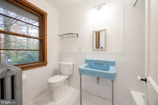 a bathroom with a toilet a sink and a window