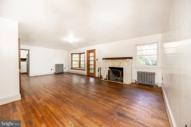 a view of a livingroom with wooden floor and a fireplace