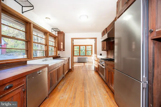 a large kitchen with a large window a sink and stainless steel appliances