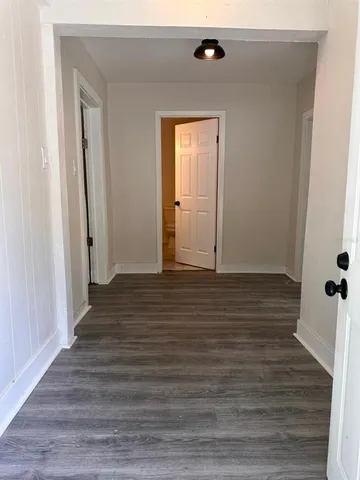 a view of a hallway with wooden floor and closet