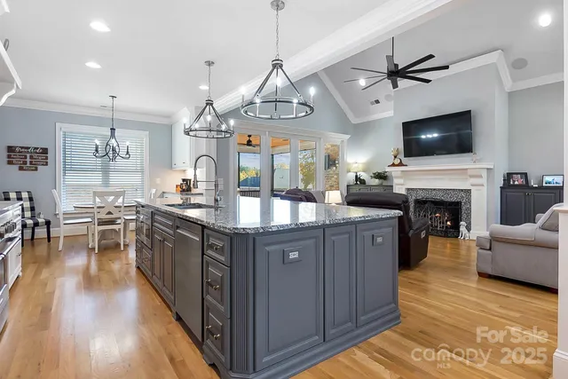 a kitchen with stainless steel appliances granite countertop a stove and a wooden floors
