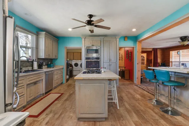 a kitchen with stainless steel appliances granite countertop a stove refrigerator and a sink