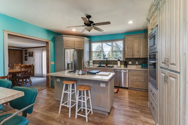 a kitchen with kitchen island a large counter top space appliances and a window