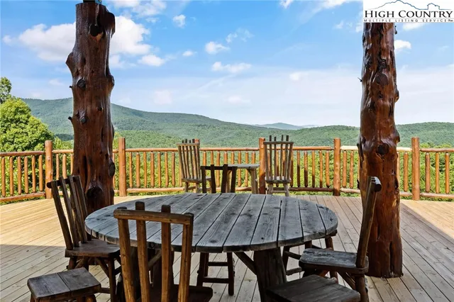 a view of a balcony with table and chairs and wooden fence