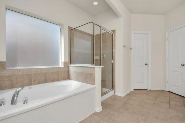 a white bath tub sitting next to a shower