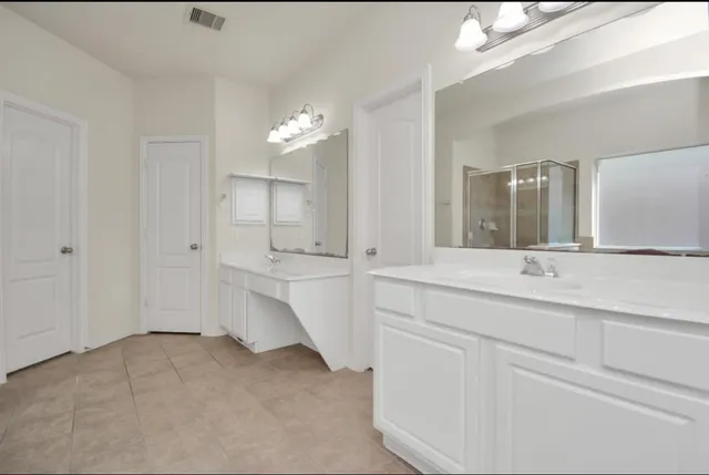 a bathroom with double vanity sink and a mirror