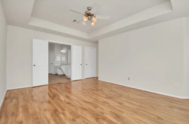 wooden floor in an empty room with a bathroom