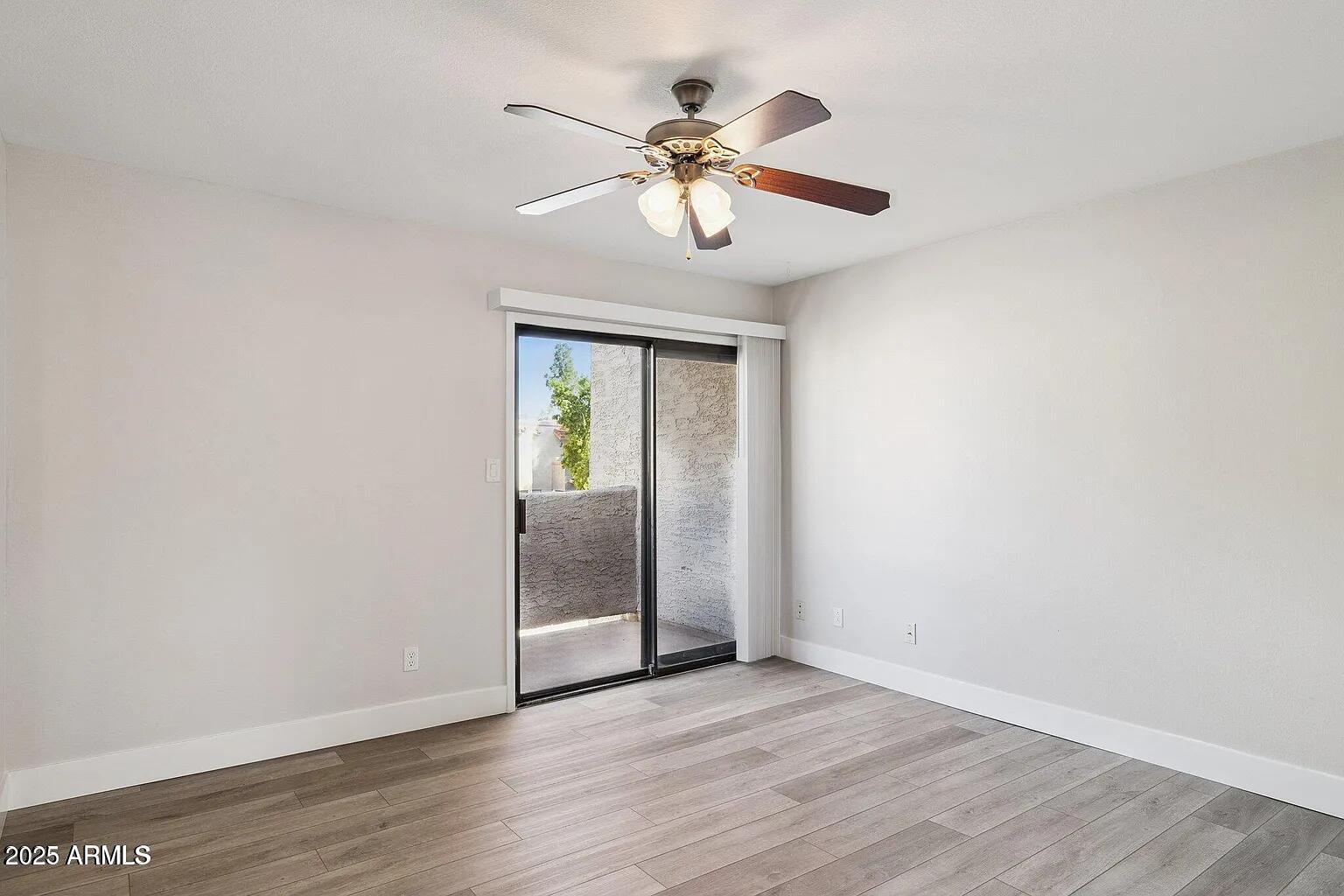 935 North Granite Reef Road, Unit 100 Scottsdale, AZ 85257 - Photo 13 of 29 an empty room with wooden floor fan and windows