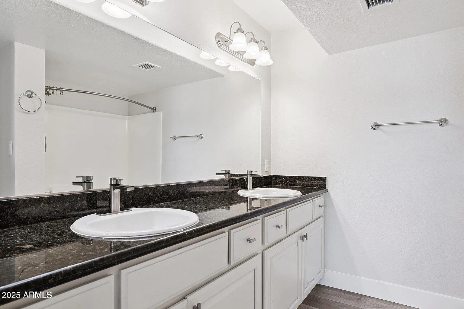 935 North Granite Reef Road, Unit 100 Scottsdale, AZ 85257 - Photo 16 of 29 a bathroom with a granite countertop sink a mirror and vanity