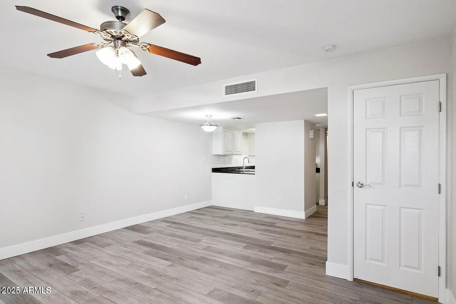935 North Granite Reef Road, Unit 100 Scottsdale, AZ 85257 - Photo 6 of 29 a view of empty room with wooden floor and ceiling fan