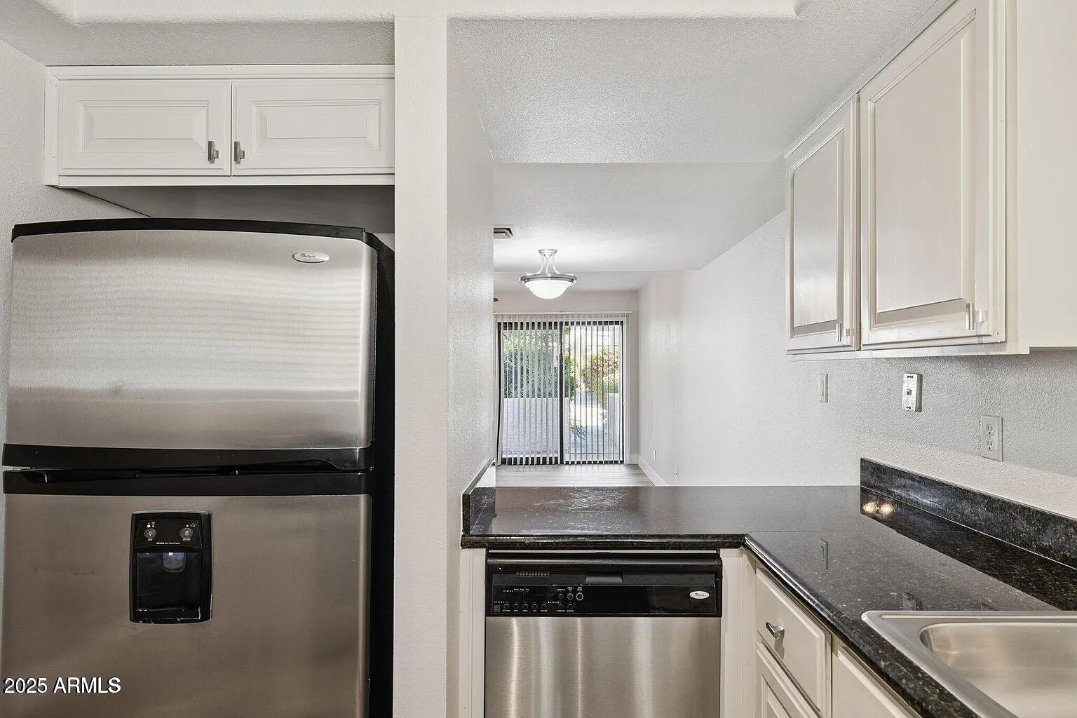 935 North Granite Reef Road, Unit 100 Scottsdale, AZ 85257 - Photo 10 of 29 a kitchen with granite countertop a stove and a refrigerator