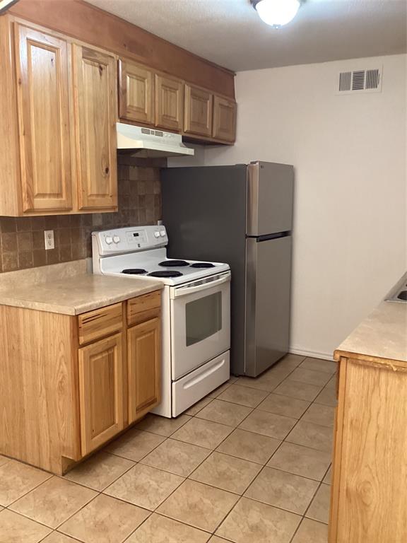 214 Locust Street South Sulphur Springs, TX 75482 - Photo 11 of 13 a kitchen with a stove top oven cabinets and a refrigerator