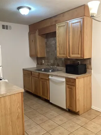 a kitchen with a sink and a stove top oven