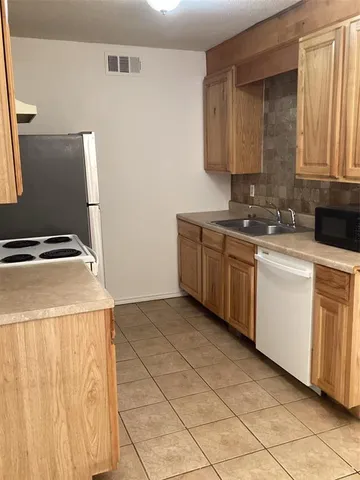 a kitchen with white cabinets a sink and white appliances