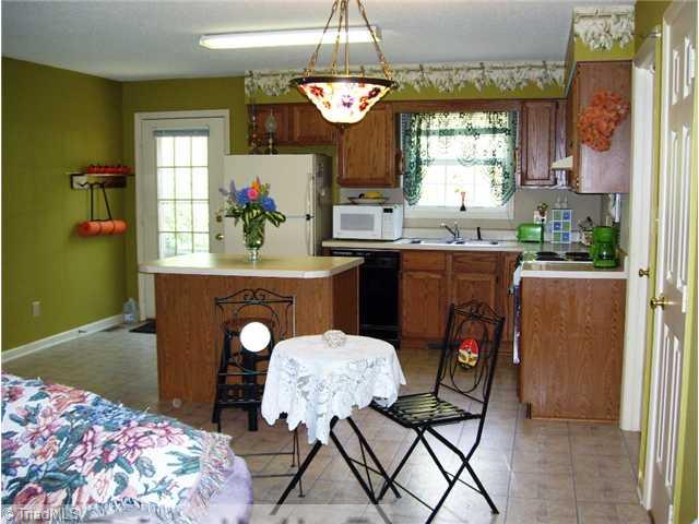 5615 Horse Farm Road Summerfield, NC 27358 - Photo 6 of 15 Kitchen. "Tiffany" light fixture does not main and will be replaced. Rear door leads to the backyard patio.