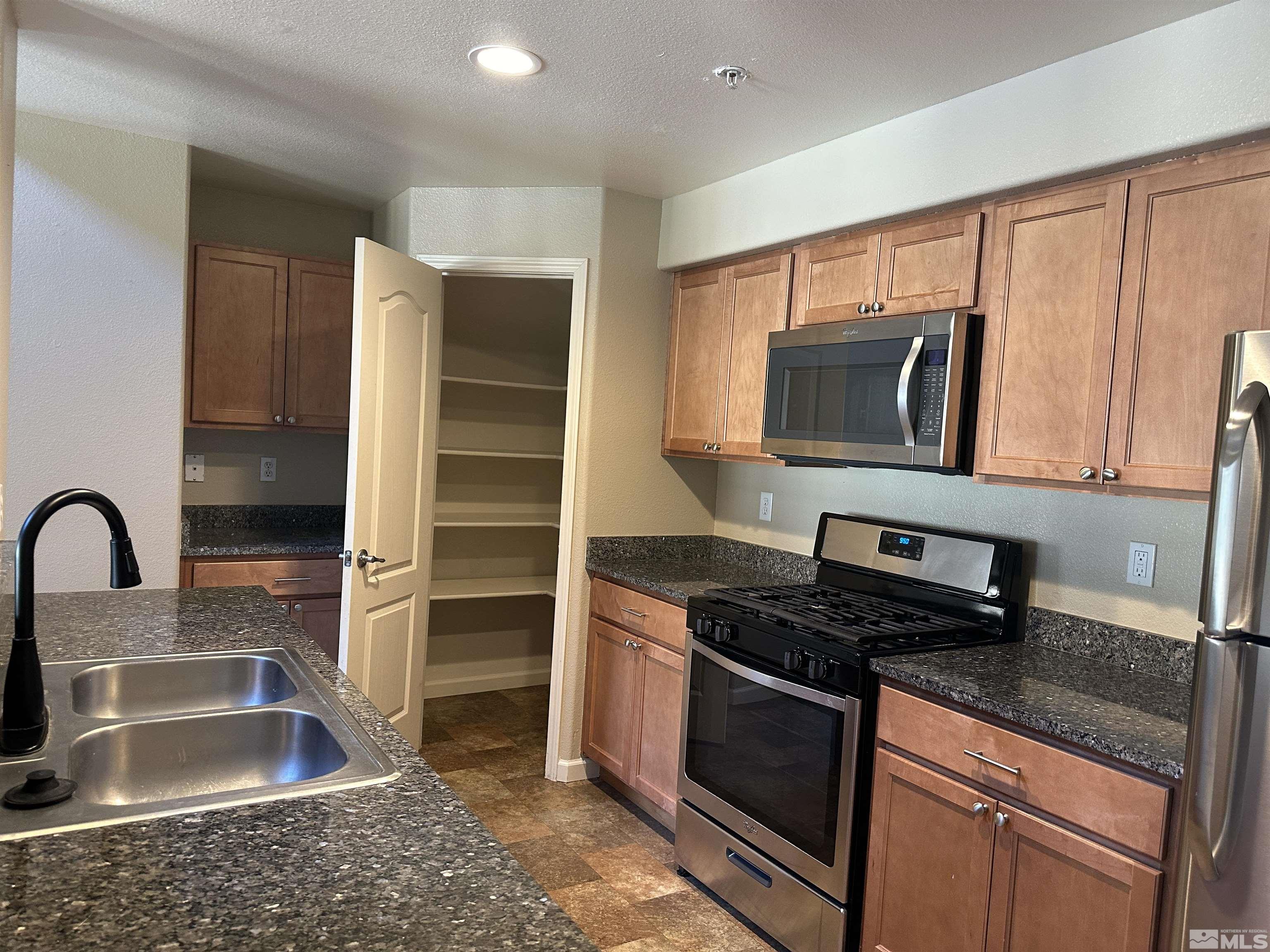 9050 Double R Boulevard, Unit 422 Reno, NV 89521 - Photo 12 of 33 a kitchen with granite countertop a stove and a sink