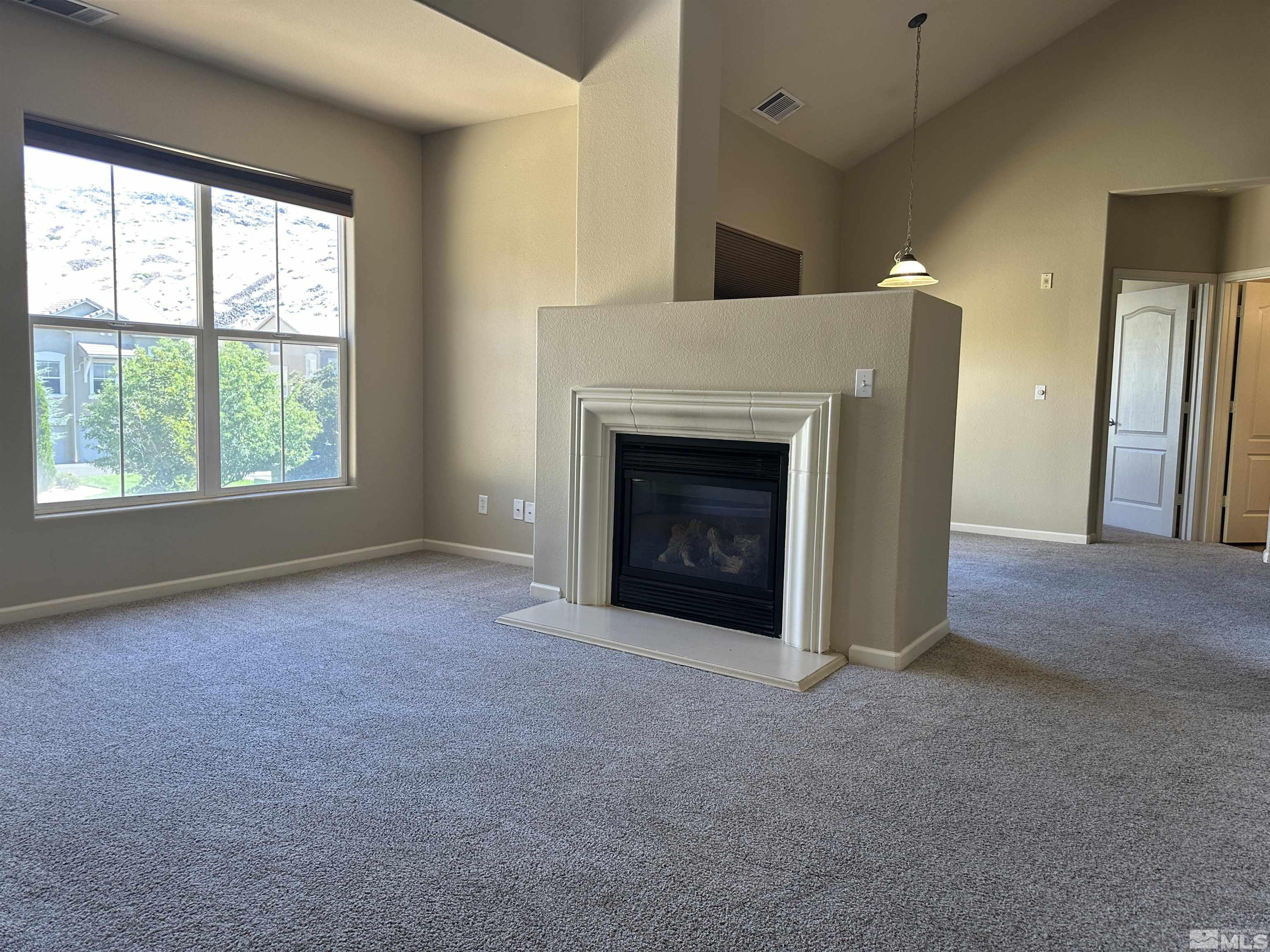 9050 Double R Boulevard, Unit 422 Reno, NV 89521 - Photo 2 of 33 an empty room with windows and fireplace