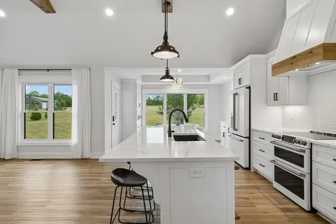 a spacious bathroom with a double vanity sink double mirror and a bathtub